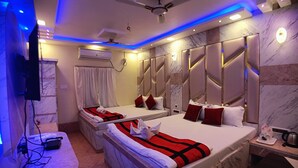 A hotel room with two beds, marble flooring, ceiling fans, and modern lighting. - Shinjini Resort (Kanthi)