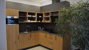 Una cucina moderna con mobili impiallacciati in legno, forno integrato e lavello.