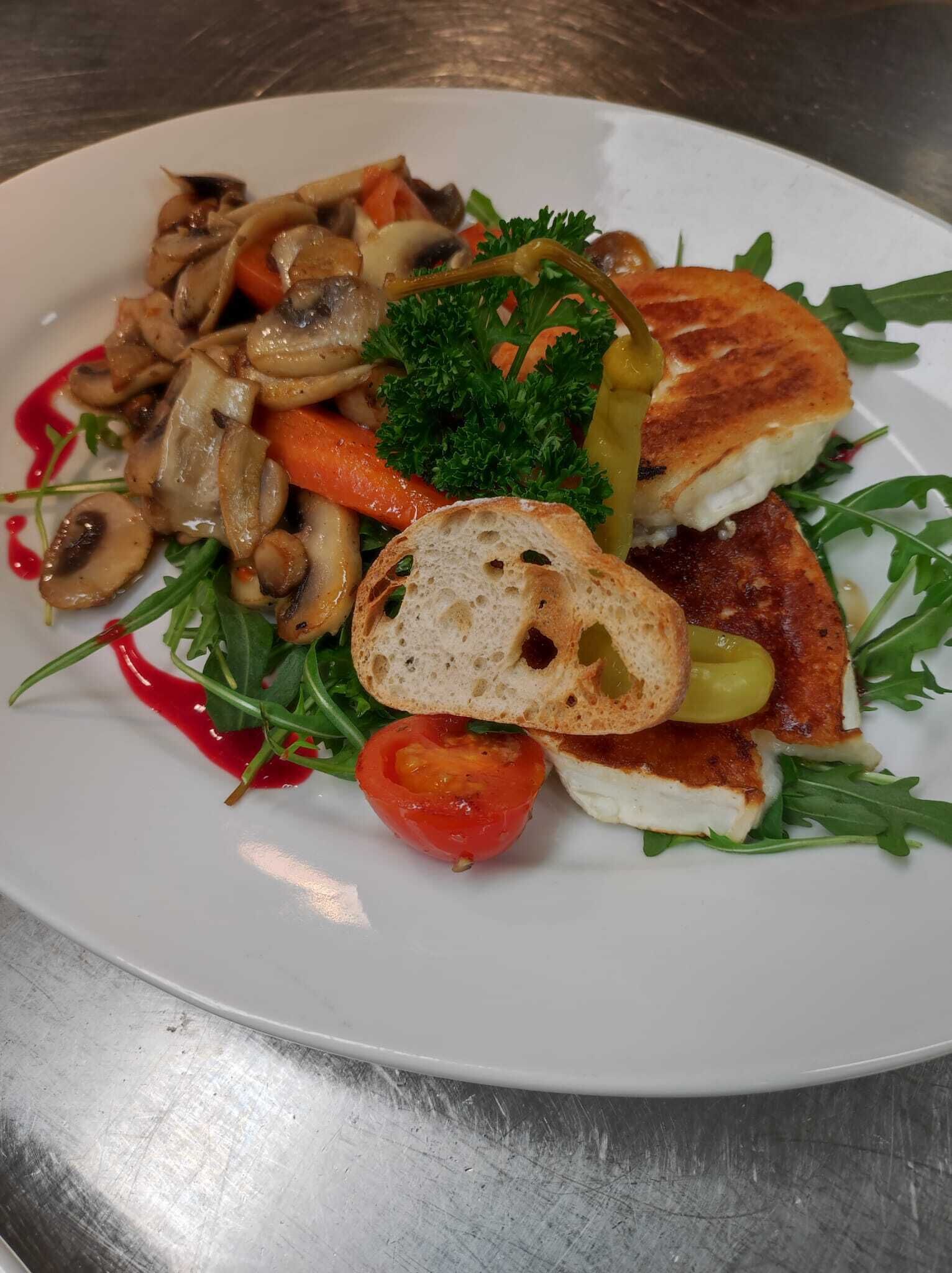 A plate of food with grilled chicken, mushrooms, carrots, and a side salad.
