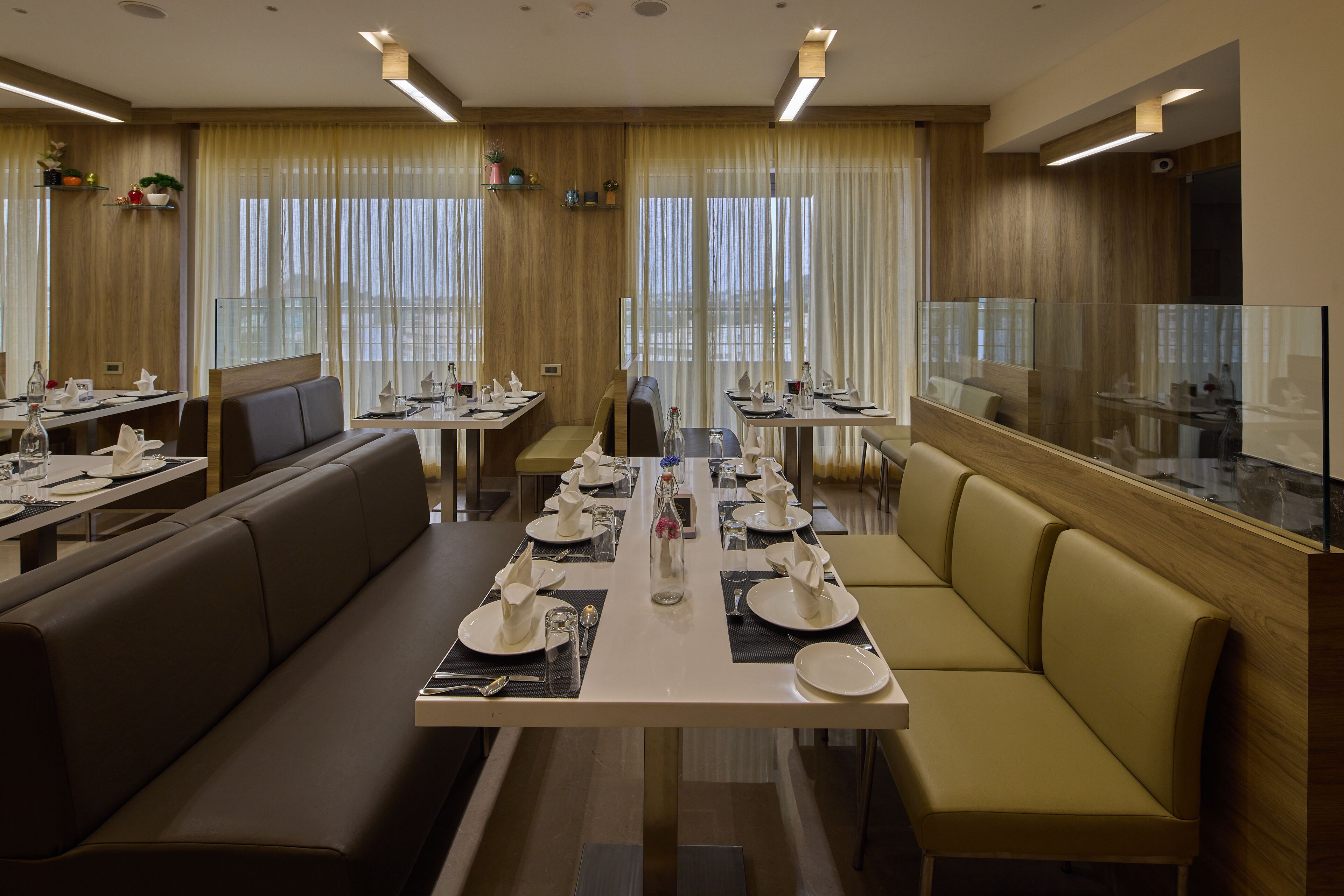 Un restaurante con una mesa larga dispuesta para una comida, cabinas y una zona de bar.