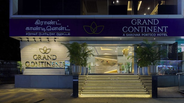 Het uiterlijk van hotel Grand Continental met een modern ontwerp, met een opvallende ingang en borden in verschillende talen.