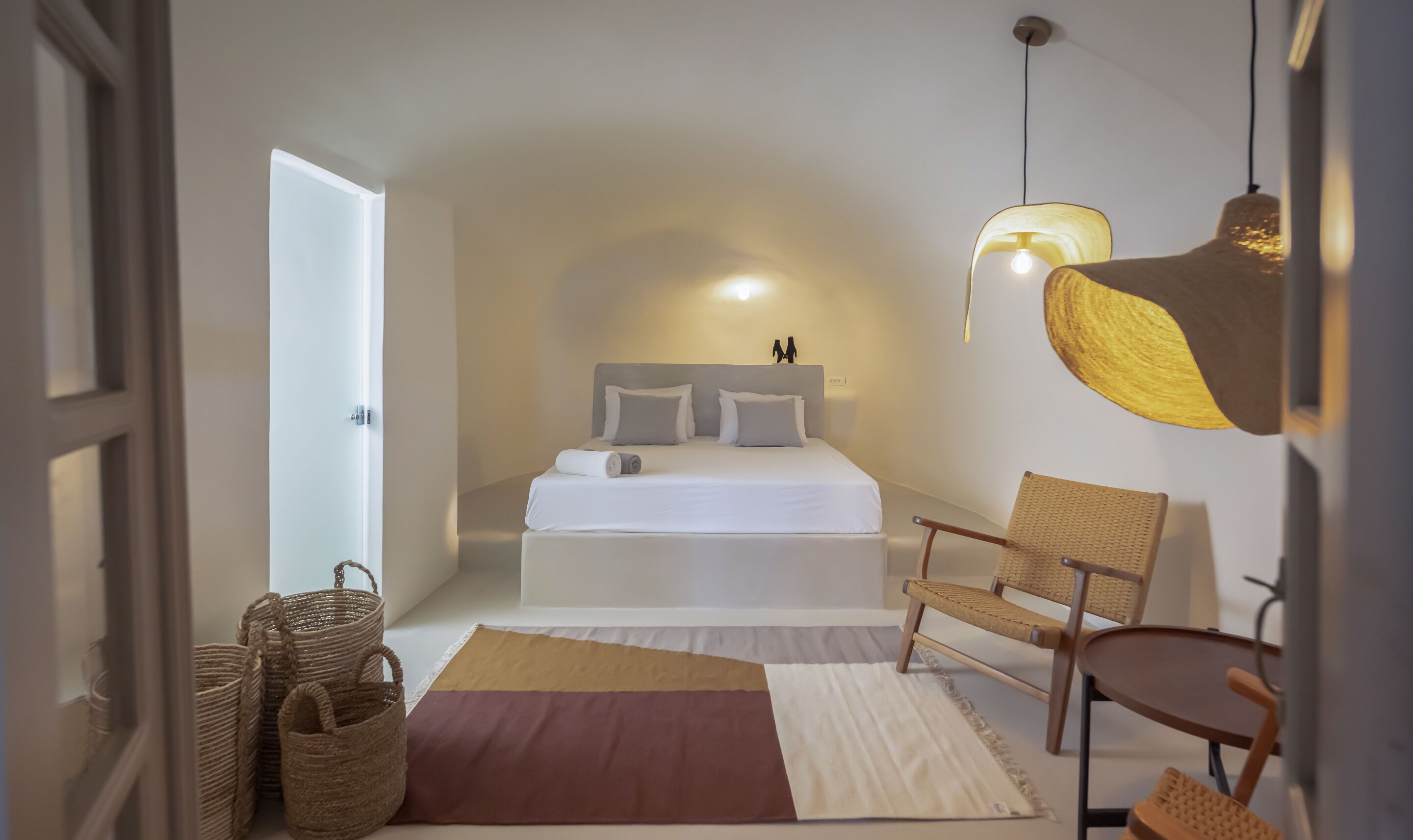 Una camera da letto con un letto, una sedia, una lampada e una porta.