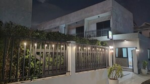 A modern building with a gated entrance, a balcony, and a sign indicating a restaurant. - The Loftel Resort (Bangkok)