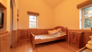 A wooden room with a single bed, a small cabinet, and a window. - Yubari City Deer Valley Residence (Yubari)