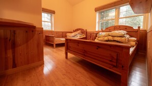 A wooden bedroom with a bed, a nightstand, and a window. - Yubari City Deer Valley Residence (Yubari)