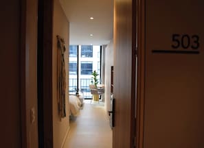 A hallway leading to a room with a view of a balcony, a door labeled '503', and a plant on the balcony. - Chic Downtown Loft - Near Zona Rosa (Bogotá)