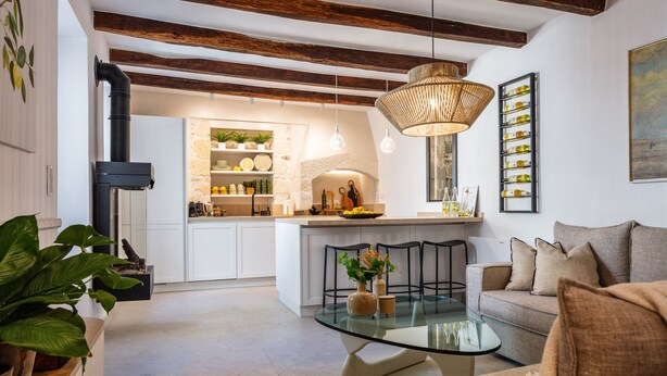 A modern kitchen with white cabinets, a central island, and a hanging light fixture. - Modern Stone Villa Lemonia w/(heated-hot tub)pool/Steam room, Old City, Rethymno (Rethymno)