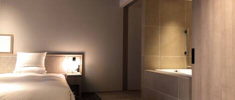 Una habitación de hotel moderna con cama, mesita de noche, lámpara y un espejo grande.