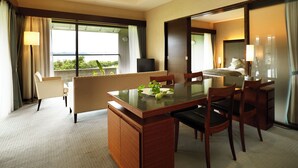 A hotel room with a dining area, a bed, a TV, and a view of the outdoors. - Hotel Anaga (Minamiawaji)