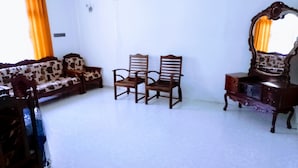 A room with a sofa, two chairs, a dresser, and a mirror. - Volga Guest House (Weligama)
