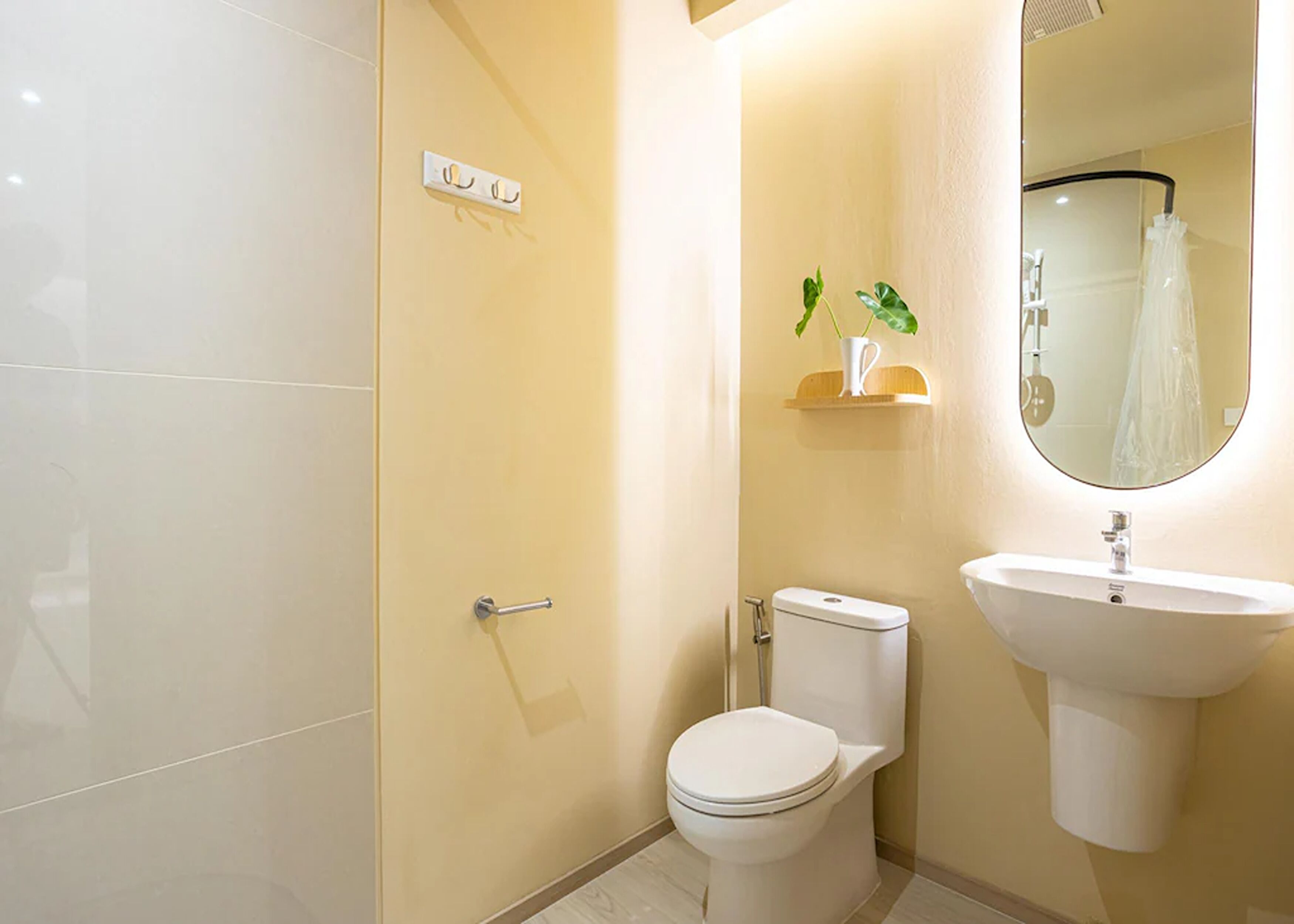 Et badeværelse med toilet, vask og bruser.