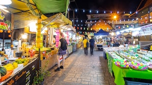 Un mercado cubierto y concurrido, con varios puestos que venden comida y productos.