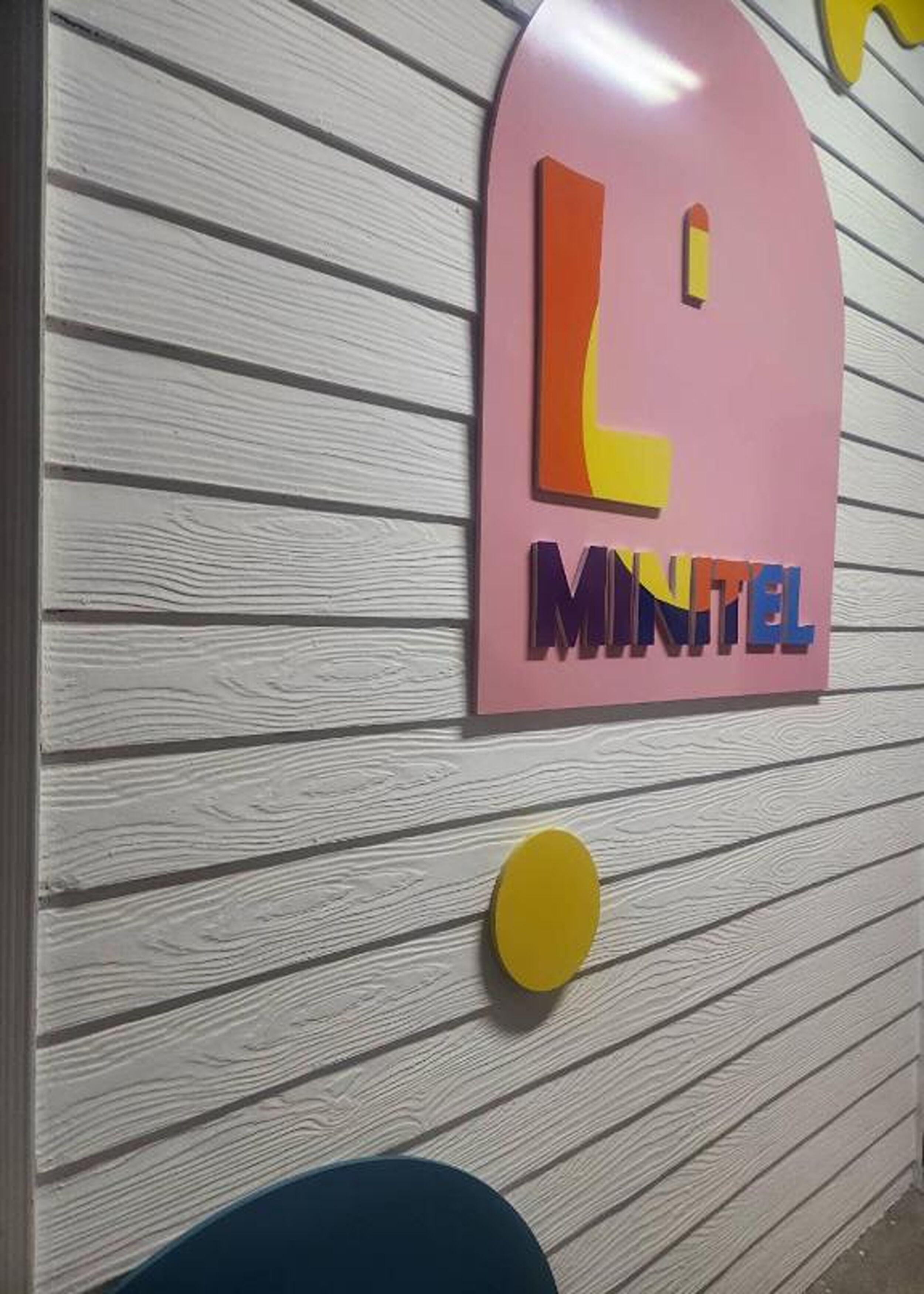 Una pared con un letrero que dice "L'MINTEL" en letras coloridas.