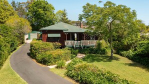 A small, single-story building with a green roof and a porch.