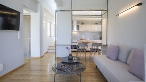 A modern living room with a sofa, a coffee table, and a TV mounted on the wall. - Villa Kymo by Thines Villas (Lefkada)
