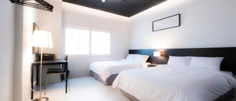 Una habitación de hotel moderna con dos camas, un escritorio y una silla.