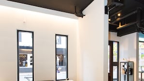 A modern interior with a sectional sofa, a small table, and large windows.