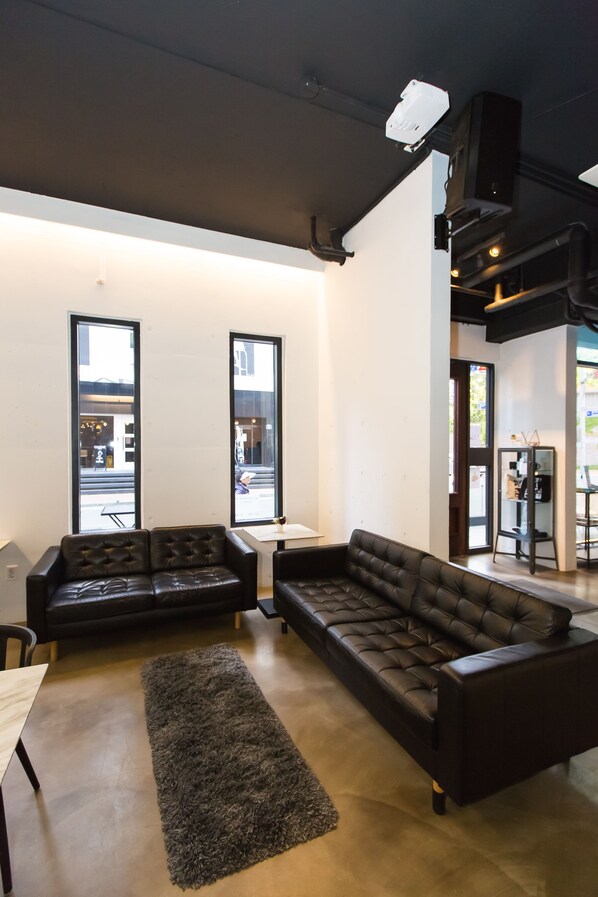 A modern interior with a sectional sofa, a small table, and large windows.
