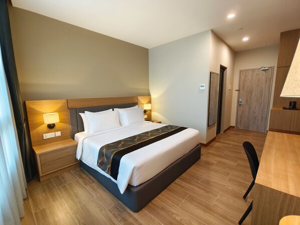 A modern hotel room with a large bed, bedside lamps, a desk, and a wardrobe.