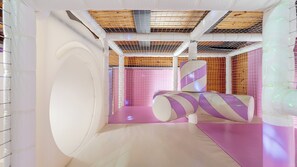 Et moderne interiør med en buet væg, et skråt loft og et pink gulv.