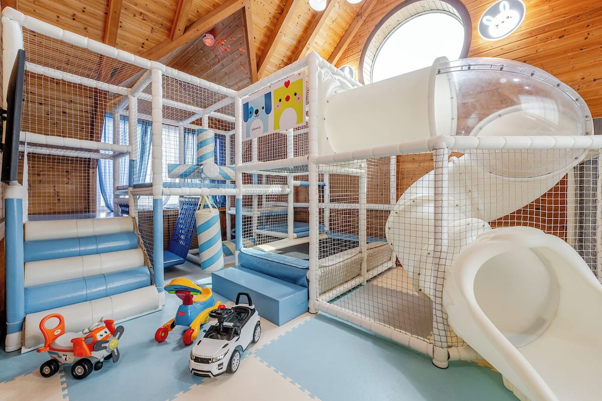 Ein Spielbereich mit Rutschen, Klettergerüsten und Spielzeugautos.