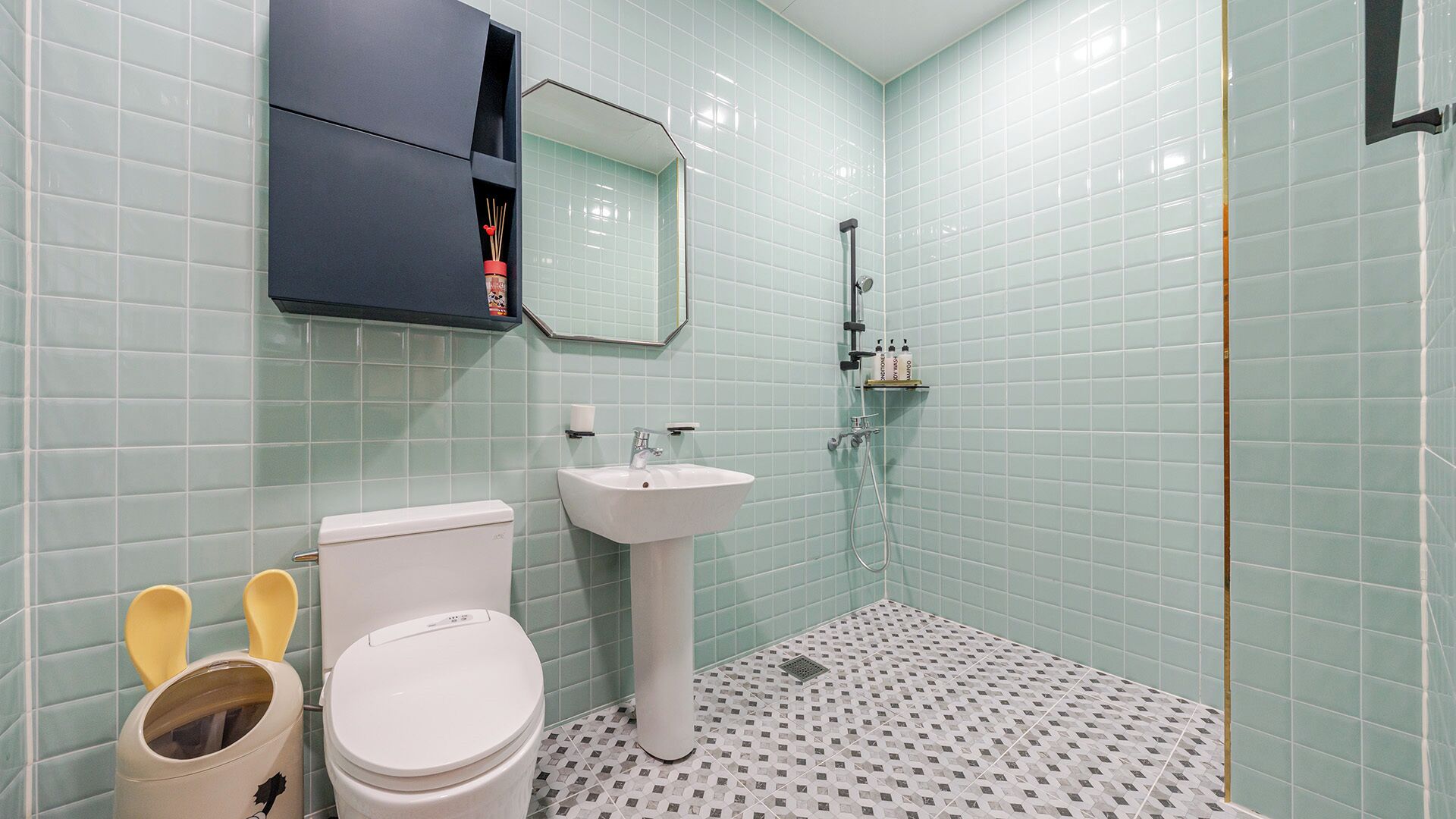 A bathroom with a toilet, sink, and shower.