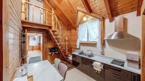 A wooden cabin interior with a kitchen, dining area, and a staircase leading to an upper level. - Gyeongju Liune Kids Pool Villa Pension (Gyeongju)