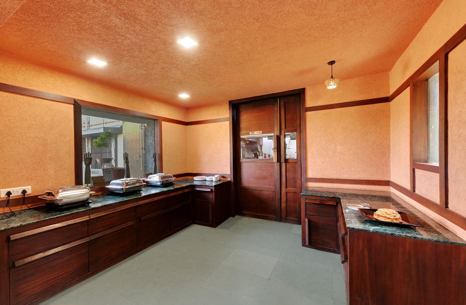 A kitchen with wooden cabinets, a granite countertop, and a view of the outside through a window.