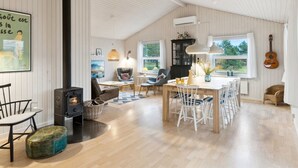 Un vaste espace de vie comprenant une cheminée, une table à manger et des chaises.