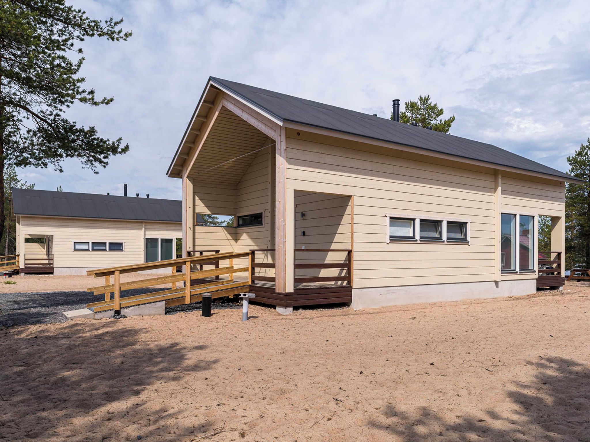 A single-story building with a covered porch and a wooden deck.