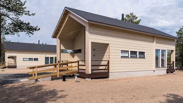A single-story building with a covered porch and a wooden deck.