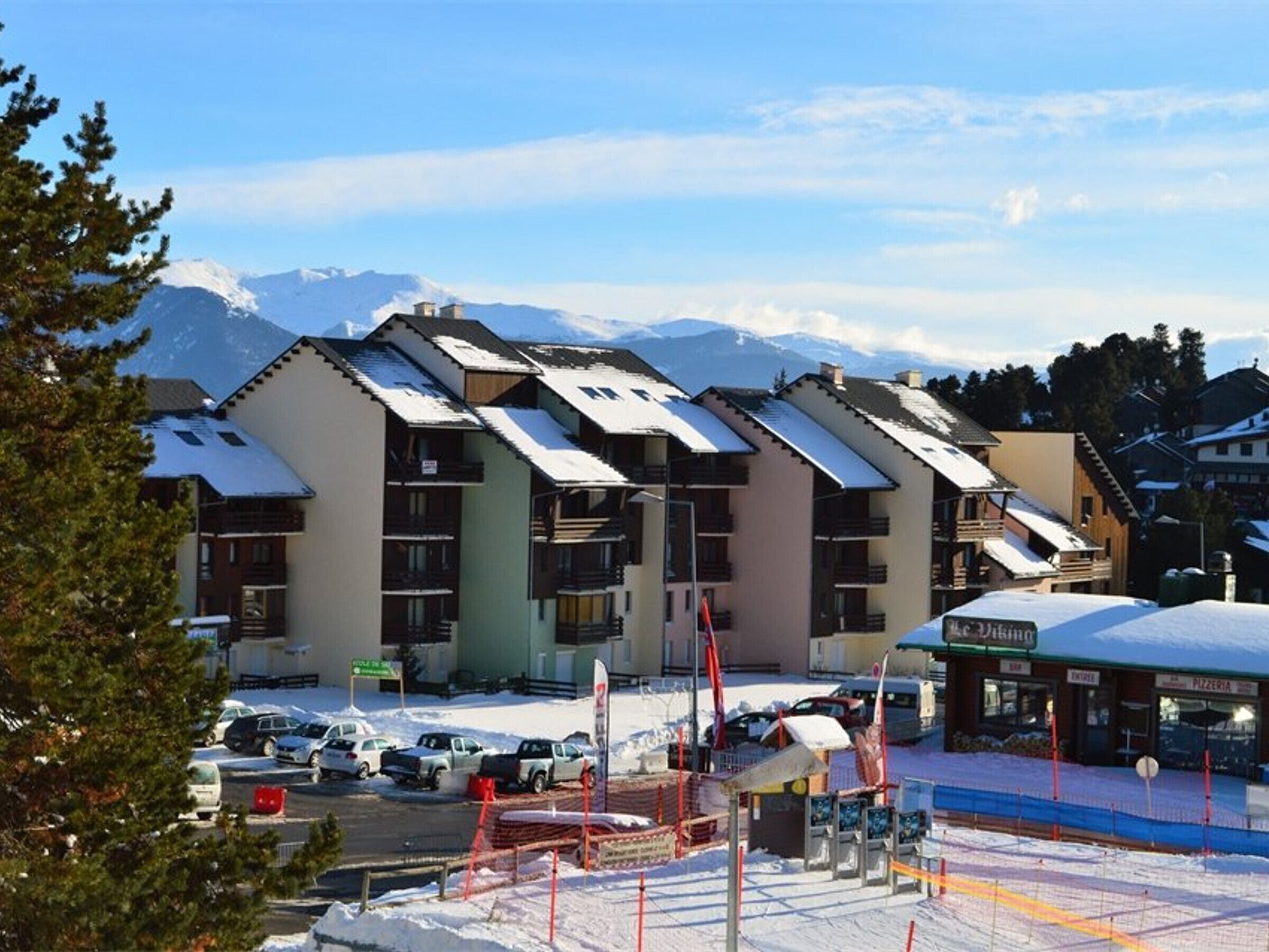 A row of multi-story buildings with a ski slope in the background.