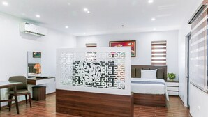 Une chambre d’hôtel moderne équipée d’un lit, d’un bureau, d’une chaise et d’un panneau décoratif mural.