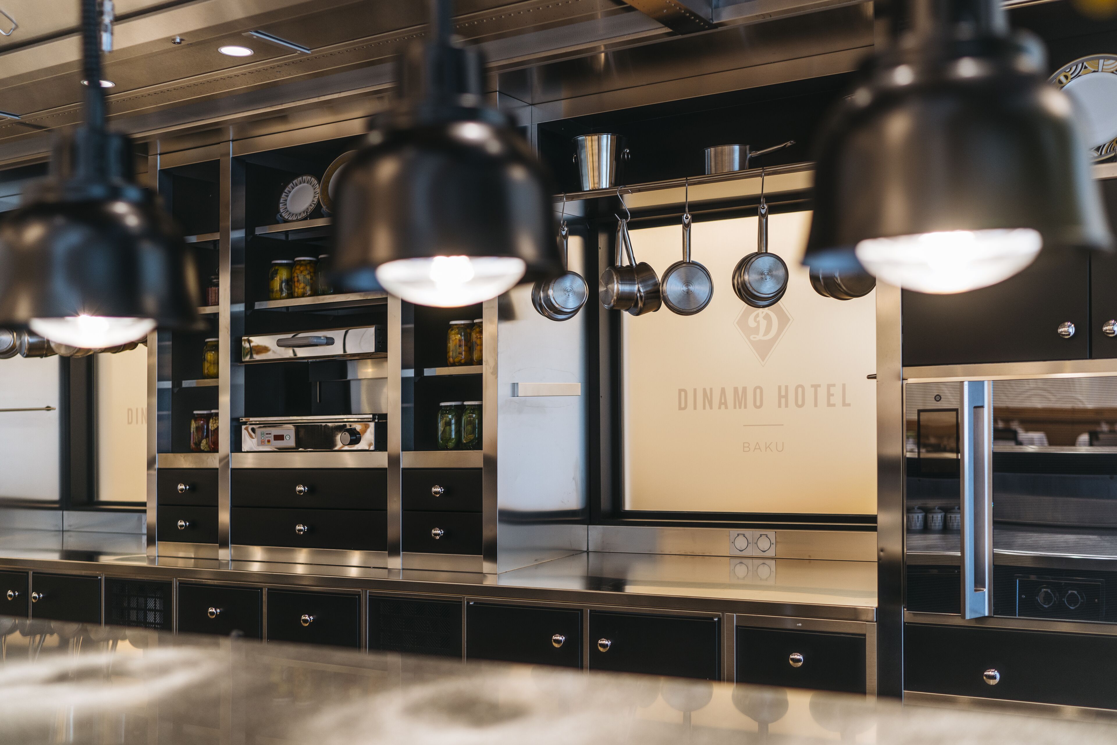 Une cuisine moderne dotée d’appareils électroménagers en acier inoxydable et de meubles de rangement noirs.