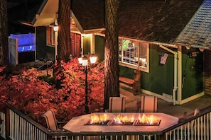 A patio with a fire feature, outdoor seating, and a building with a porch.