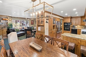 A spacious kitchen with wooden cabinets, a dining area with a wooden table, and a cozy living room with a sofa and a coffee table.