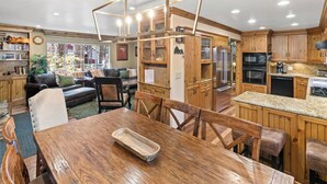 Una cocina amplia con armarios de madera, encimera de granito y electrodomésticos modernos.