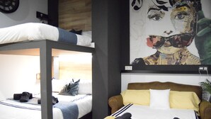 A room with two beds, one with a bunk and the other with a single bed. There is a large painting on the wall above the beds. - Apto 41. Residencial Alcoy (Alcoi)