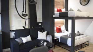 Et moderne, flerplansværelse med køjesenge, en sofa og et sofabord.