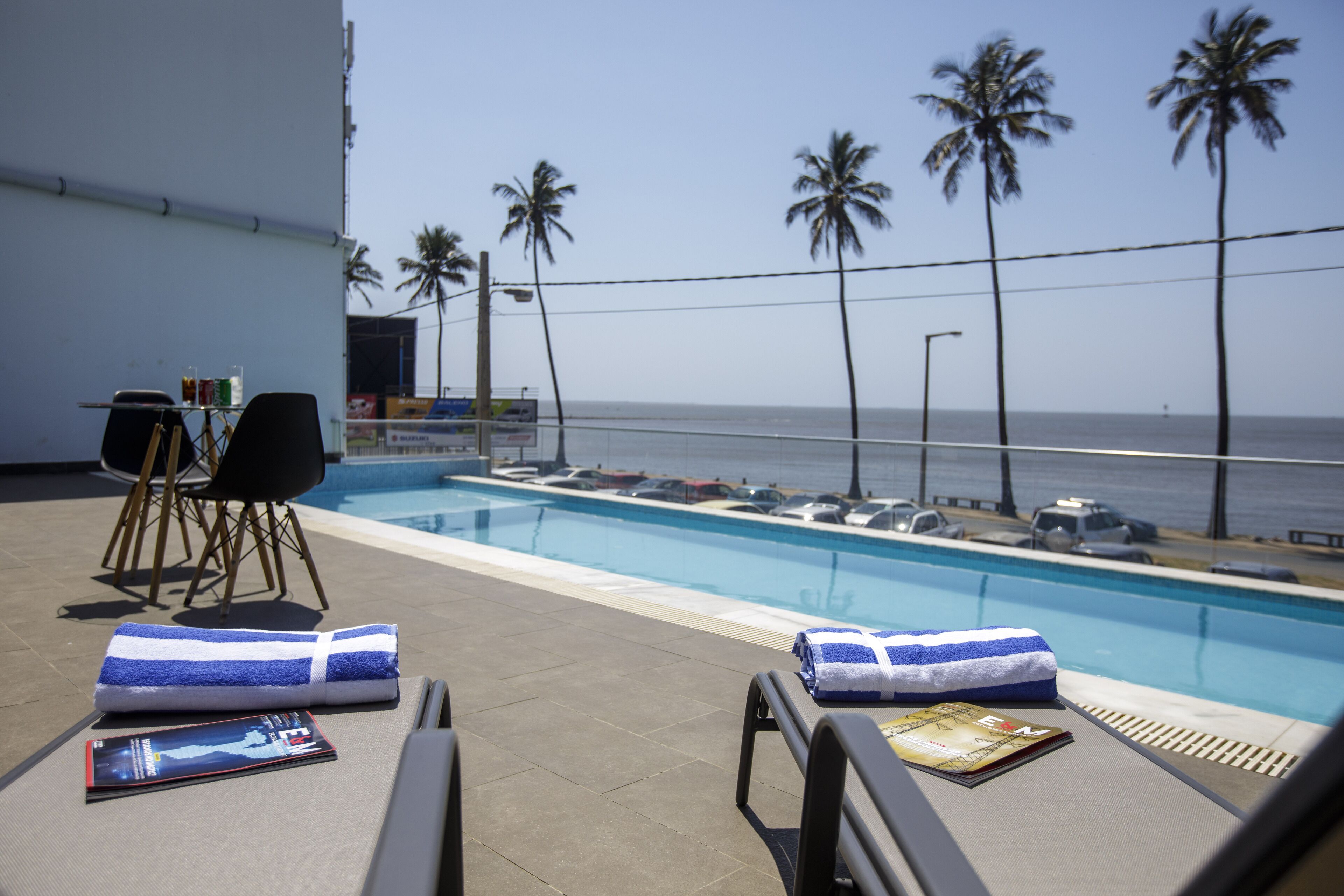A poolside area with lounge chairs, a towel, and a magazine.