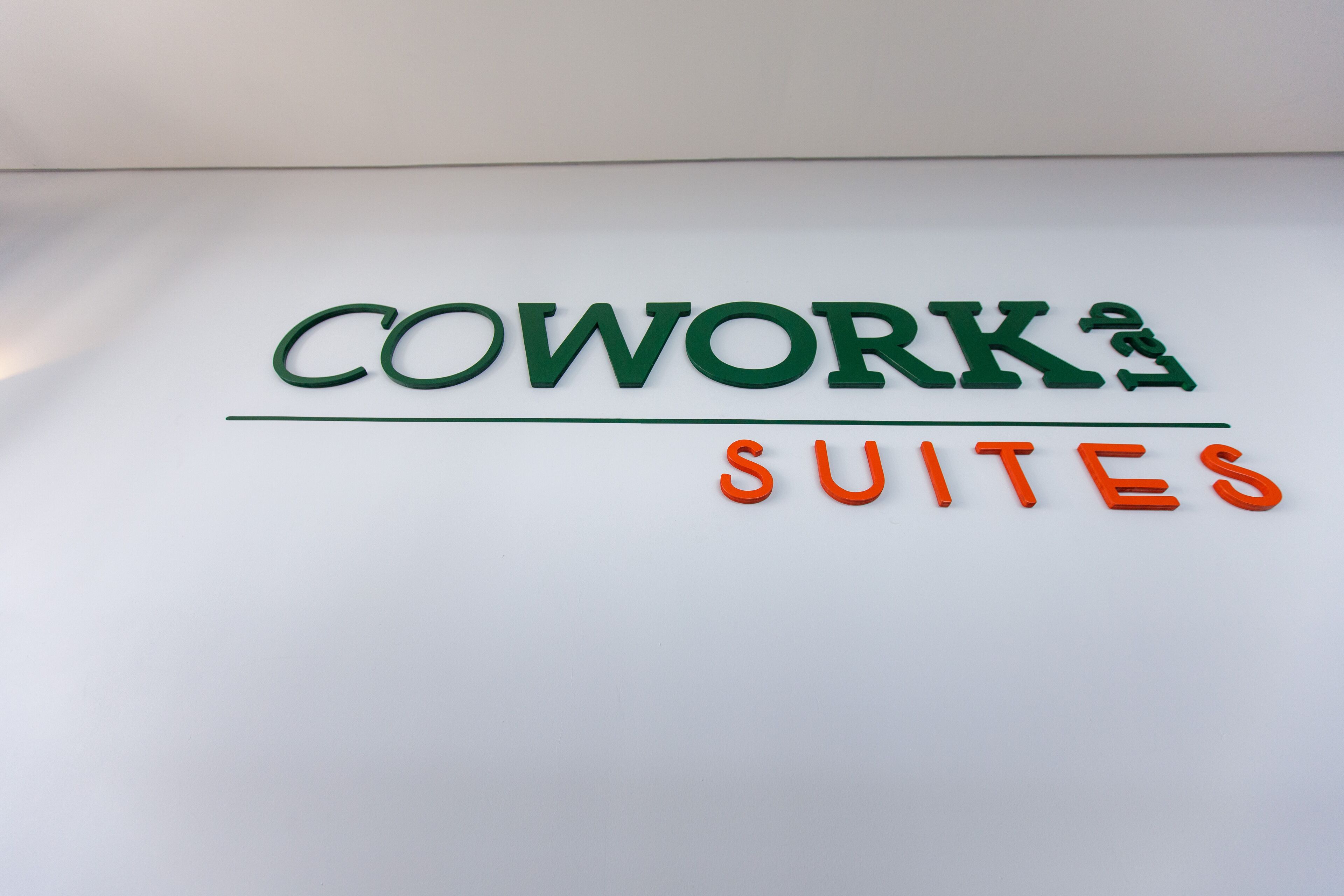 Um sinal com o texto 'Cowork's Suites' num fundo branco.