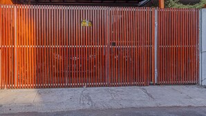 Una reja metálica cerrada con un letrero que dice "No. 3" y una cerca de madera.