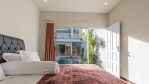Un dormitorio con cama, vista a una piscina y balcón.