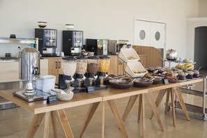 A buffet setup with various food items and a coffee station.