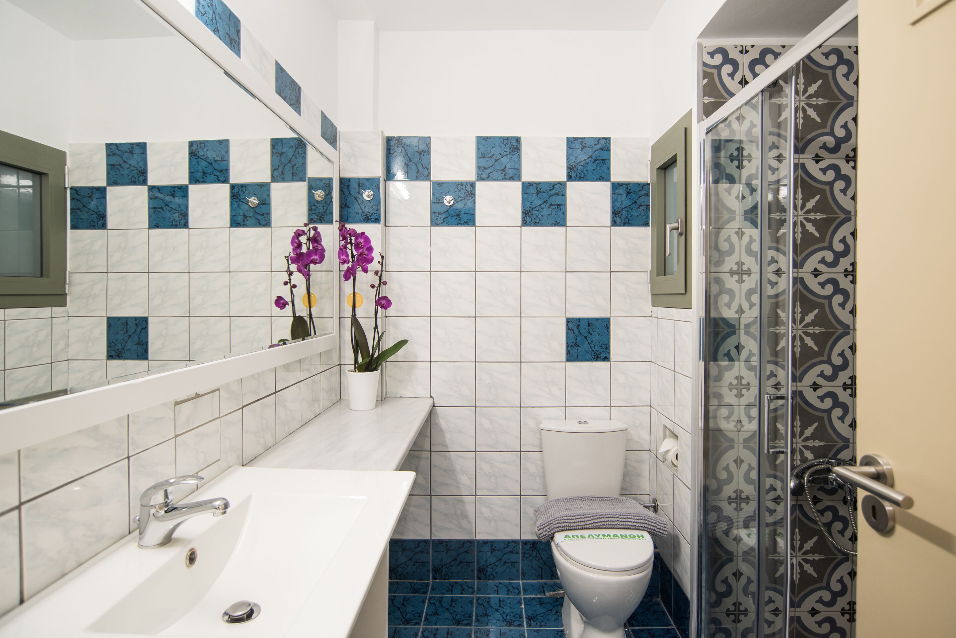 Un baño con lavamanos blanco, inodoro y zona de ducha.