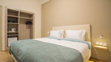 Ein ordentlich eingerichtetes Schlafzimmer mit Bett, Kleiderschrank und Nachttisch mit Lampe.