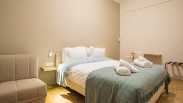 A bedroom with a bed, a bedside table, a chair, and a nightstand.