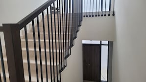 A staircase with a black railing leading to a landing. - Villa Elena Hayat Island Marbella (Ras Al Khaimah)