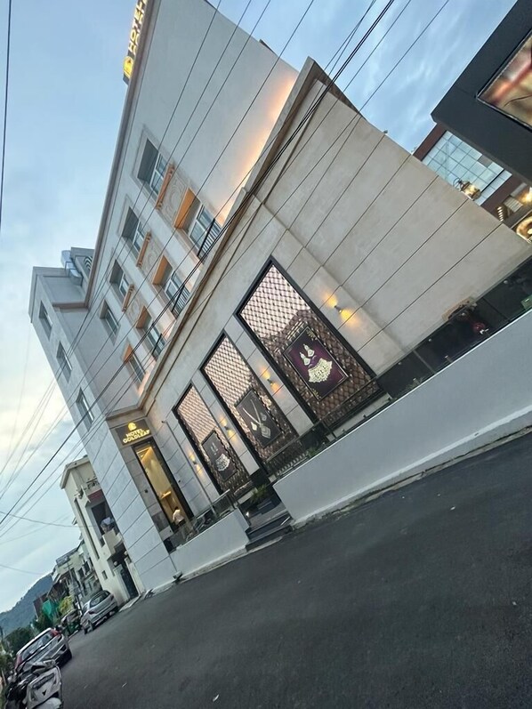 A modern hotel with a prominent sign, large windows, and a clean facade.