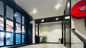 Eine moderne Treppe mit Granitstufen und einem Glasgeländer, die zu einem Raum mit einem großen Fenster und einem roten, runden Gegenstand an der Wand führt.